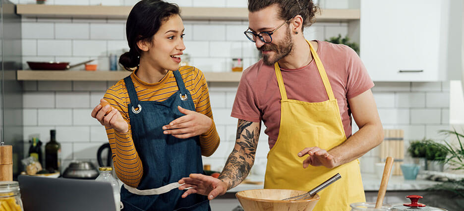 Junge Menschen kochen mithilfe des Internets