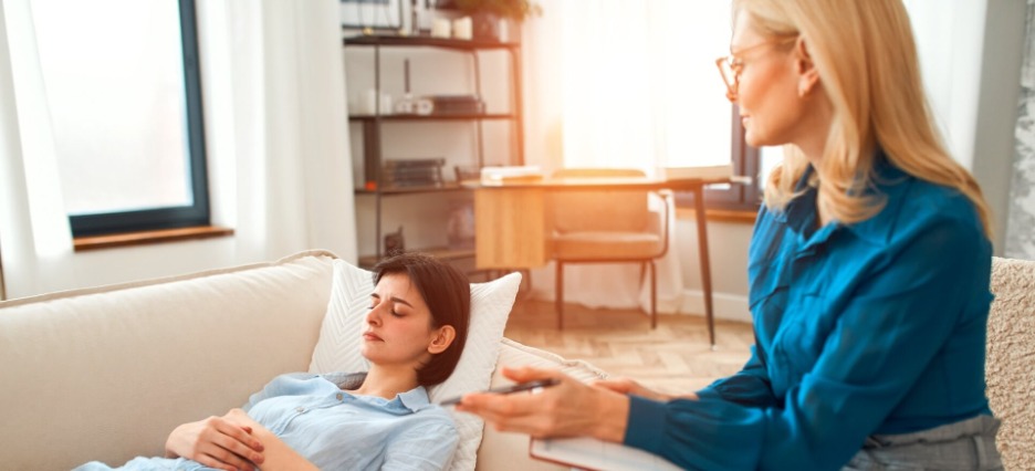 Psychoanalytikerin beobachtet Patientin, die auf einer Couch liegt